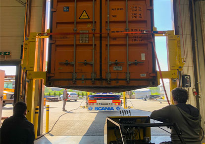 The truck drives to the loading of the container lifted by lifting jacks